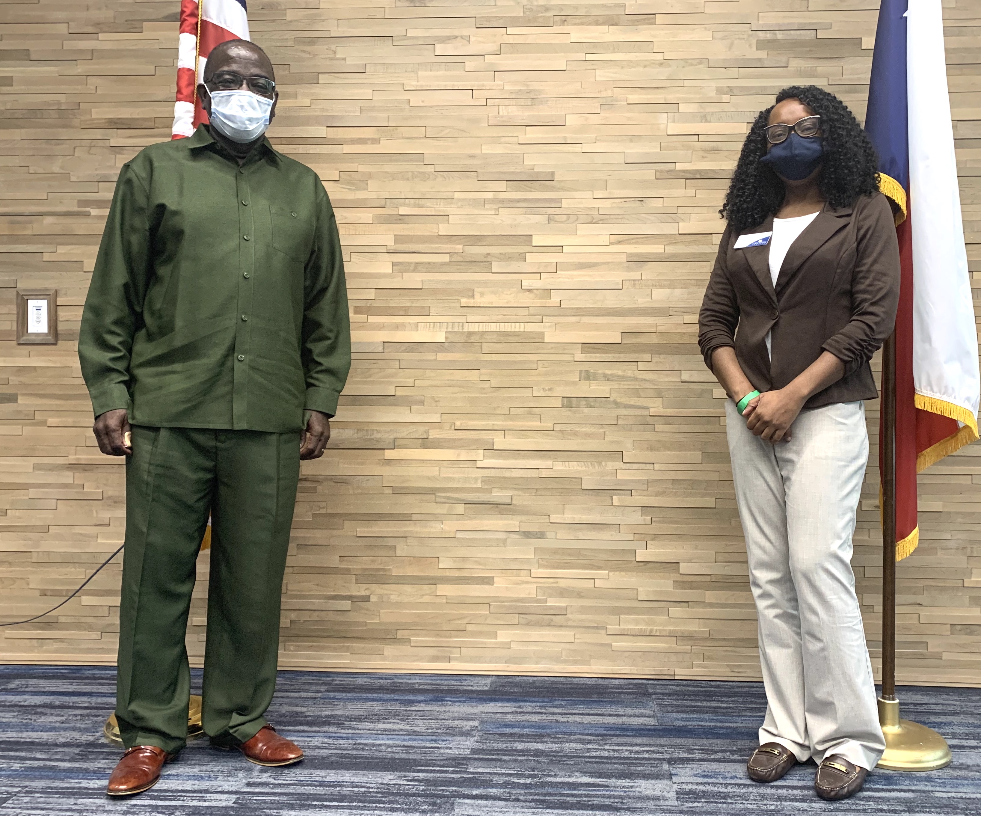 Terrence Steele standing next to American flag at board meeting