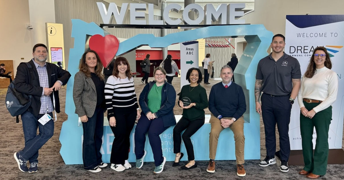 Grayson College Staff posing for picture under welcome sign at Achieving the Dream annual conference