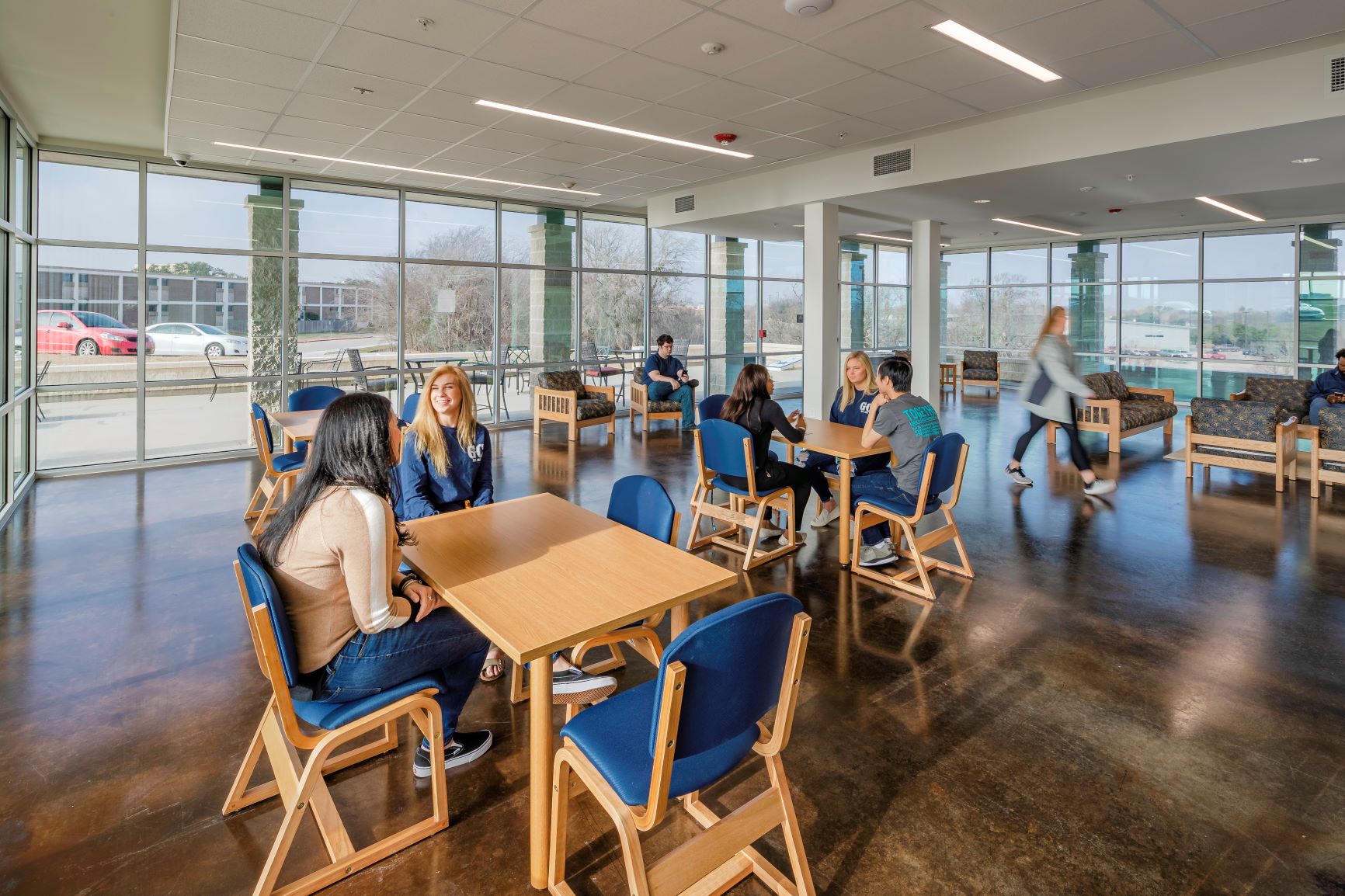 Indoor meeting space with several seating units, windows lining room