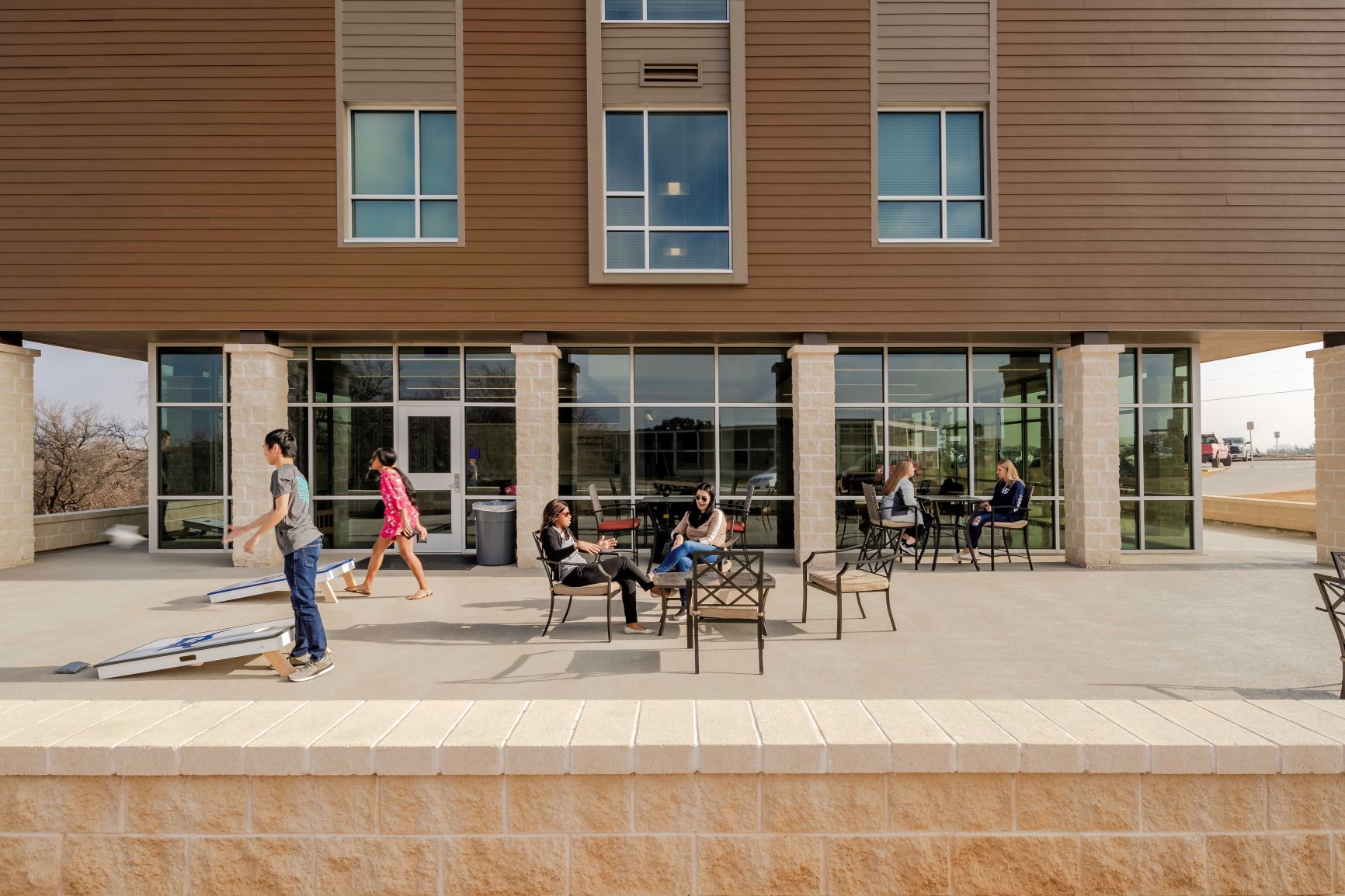 Jones Hall outdoor patio with students playing cornhole