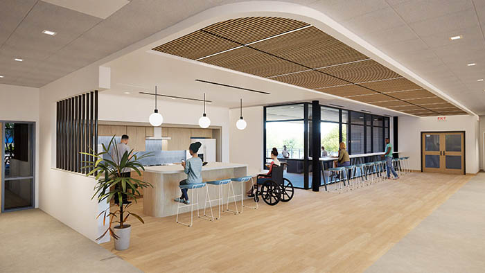 Artist Rendering of Communal kitchen area with island, one person cooking and stove, one seated at island, and one person in a wheelchair next to island