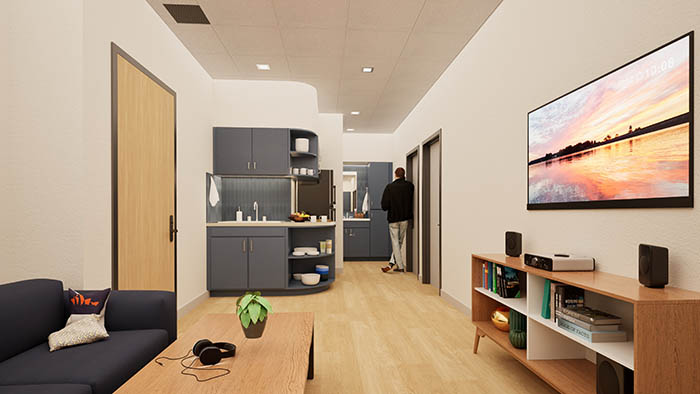 Artist rendering of living area in quad suite, featuring futon, coffee table, kitchenettem tv and entertainment shelving.