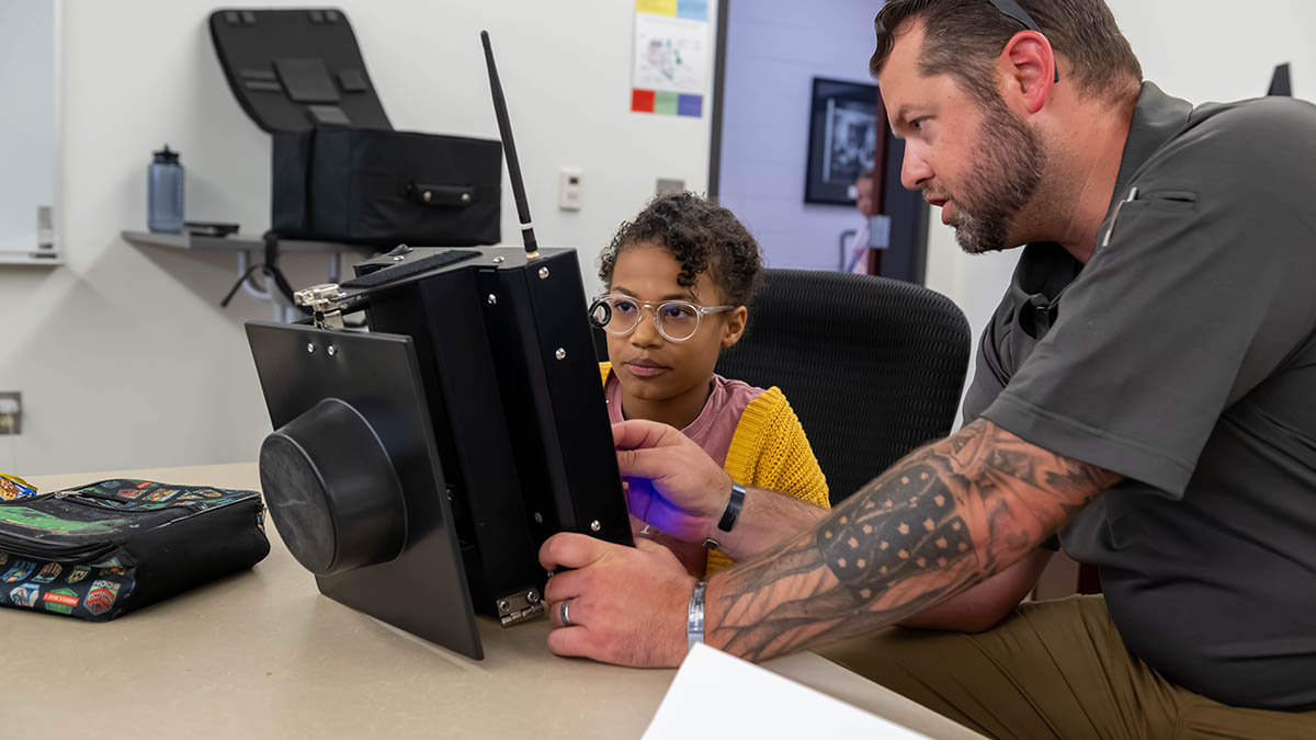 Camper views output on a monitor with instructor