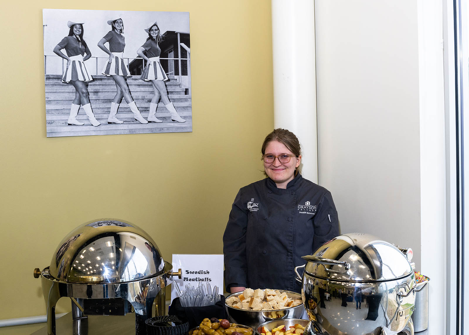 Event staff member smiling in front of Swedish Meatball serving station