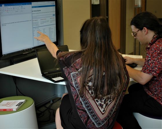 Woman pointing at collaboration station computer screen