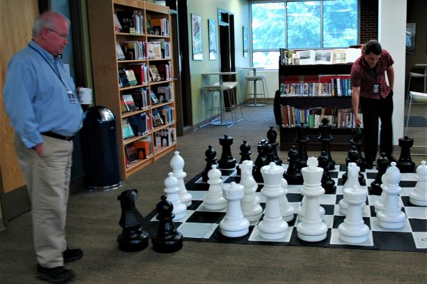 Two people playing an over-sized chess game