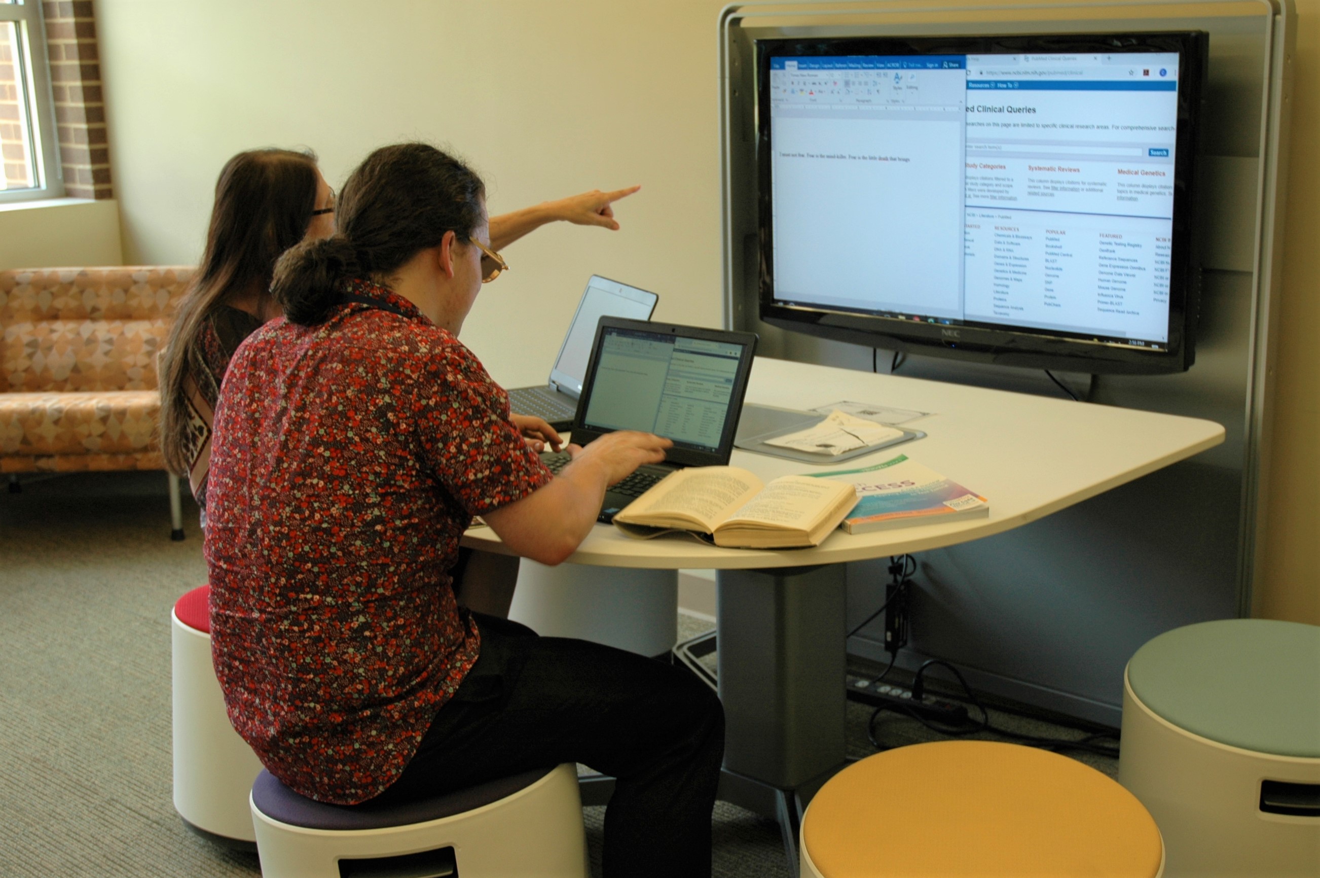 Two students seated at collaboration station computer