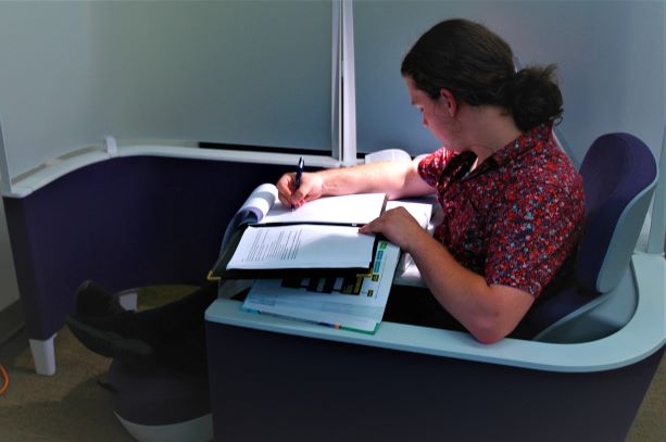 Student seated in study pod furniture