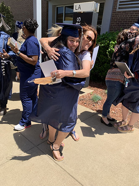 Student celebrating commencement with a hug