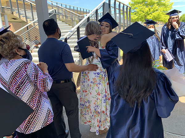 Student celebrating graduation with a hug