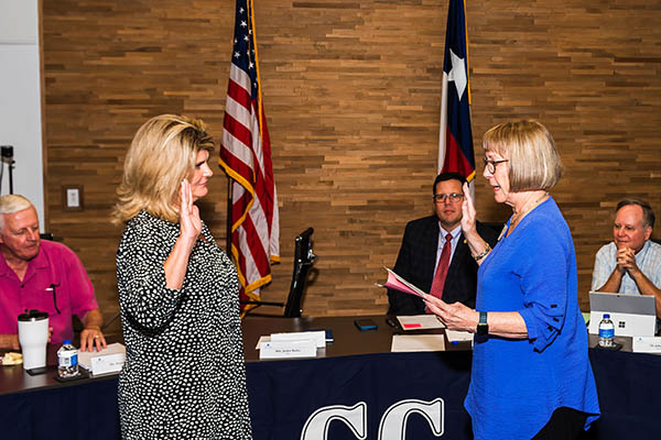 woman being sworn in in front of table with Board members