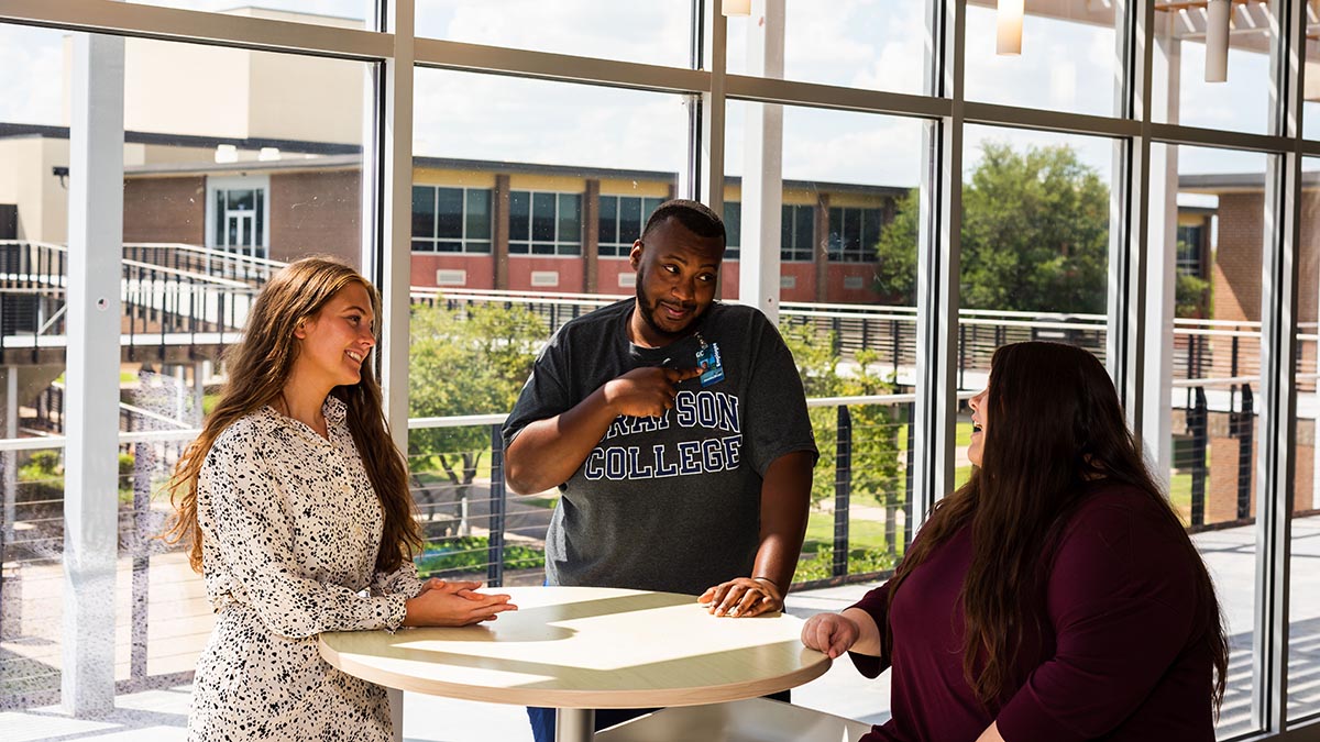 Three Grayson College Employees talking around table