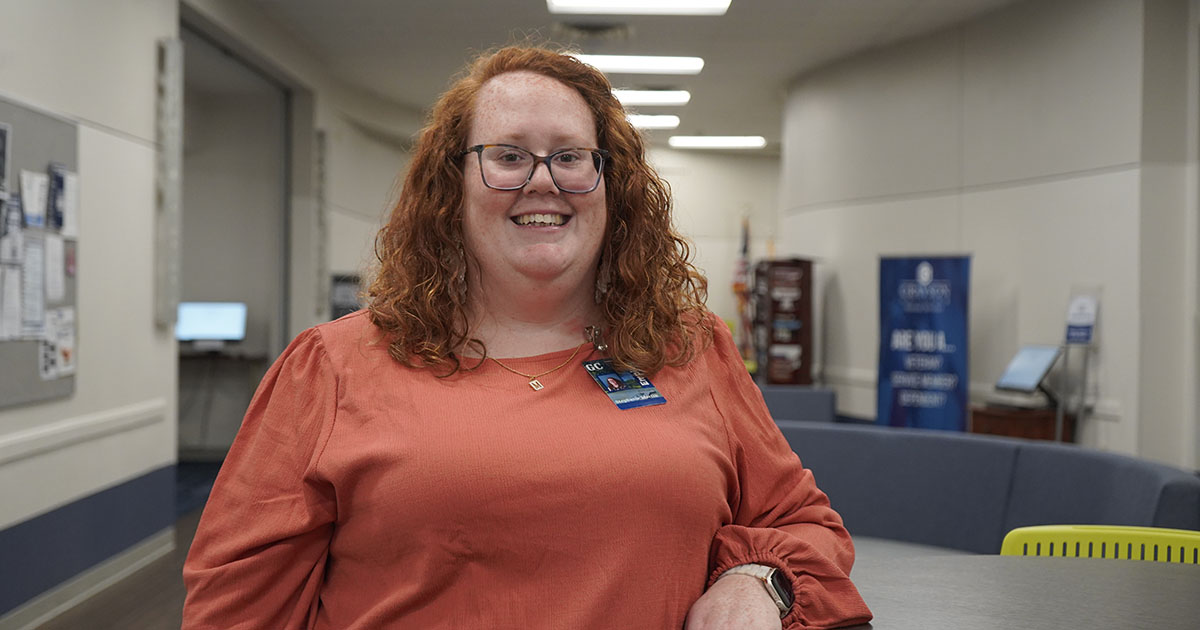 Smiling woman leaning on desk in lobby area