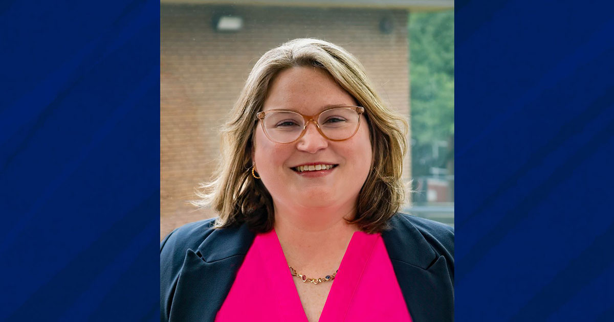 Alison Soeder headshot wearing glasses and pink blouse with black coat