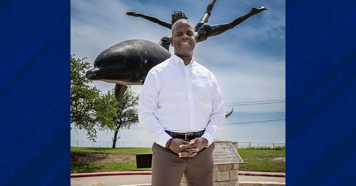 Marcus Freeman standing in front of Dolphin and Child statue