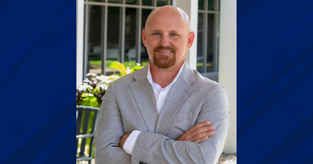 Doyle Roy smiling with arms crossed in sportcoat