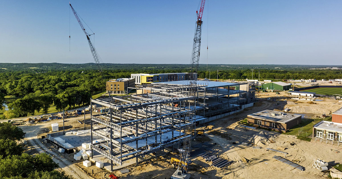 Drone view of construction on campus featuring two tall cranes