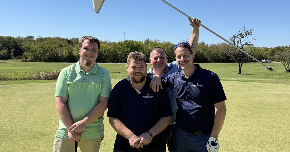 Team celebrates golf tournament holding up flag