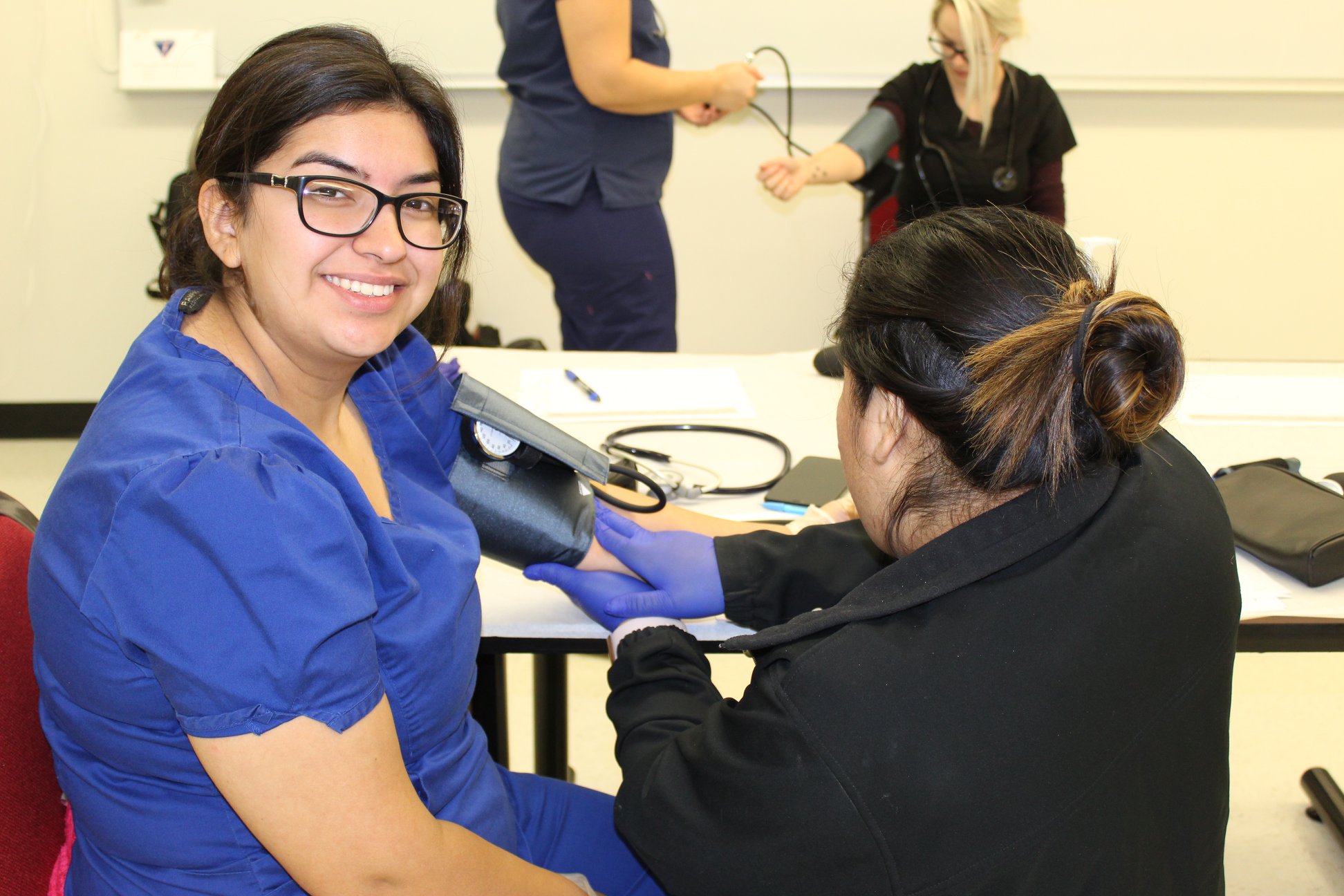 Health science students taking blood pressure