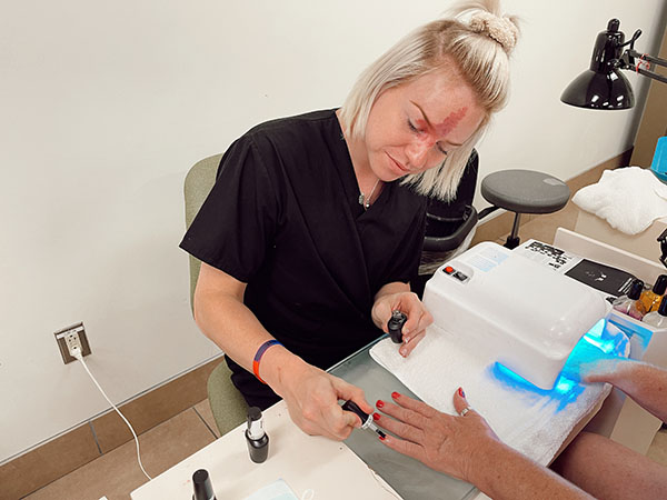 Cosmetology student performing manicure